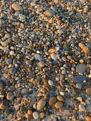 Cobble stone beach background texture close up at sunset in Esposende, Portugal.