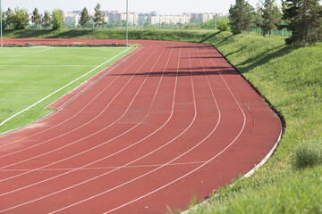Running track and field with green grass at stadium