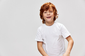 Cheerful red-haired boy on a white T-shirt smile close-up 