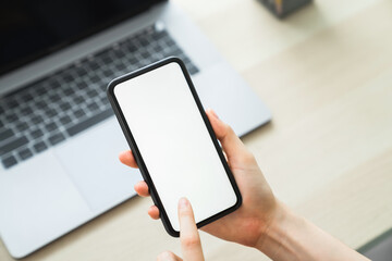 Woman hand holding smartphone and touching blank screen. Mockup of advertisement.