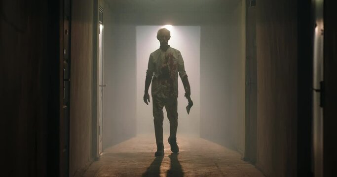 Maniac carrying a murderous weapon escaping from crime scene. Bloodthisty criminal carrying an axe in hallway of old house 4k footage