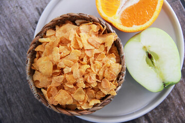dry Breakfast muesli on a plate and fruit Apple and orange