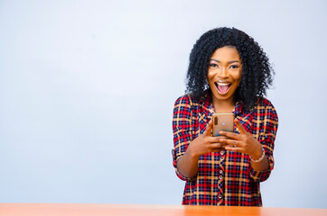 a young beautiful african american lady feeling excited about what she was on her cellphone
