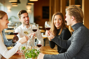 Friends celebrate together and drink a wine