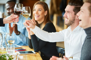 Friends toast with glass of wine in the restaurant