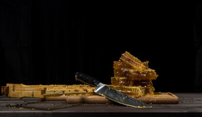 Organic rustic honey in combs lies on a cutting board. Copy space. The concept of beekeeping in agriculture.