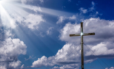 cross with sunbeamin in the sky