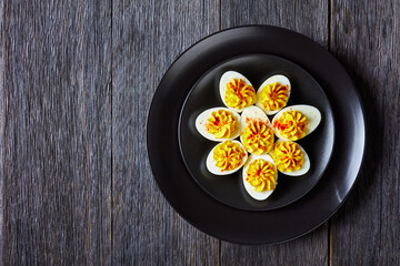 Deviled eggs on a black plate, copy space