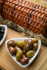 different types of olives on a dark concrete