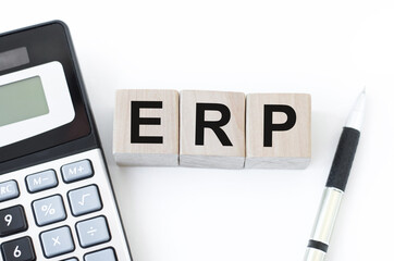 concept of ERP word on wooden cubes lying on white background with calculator and pen