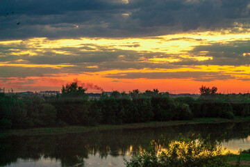 beautiful river Bank under a cloudy sky at sunset