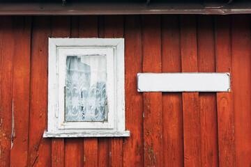 Wooden window background. Empty copy space rustic cottage house. Vintage cabin red paint wall. Countryside architecture texture. Street name blank label.