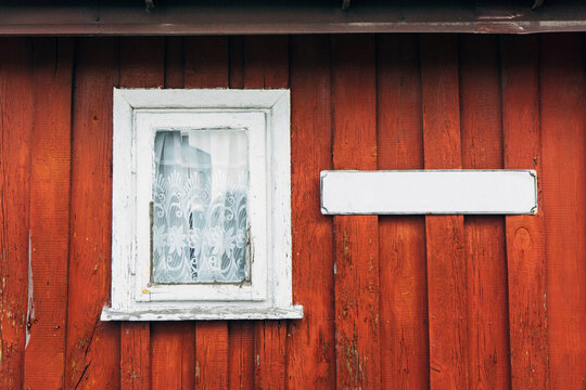 Wooden window background. Empty copy space rustic cottage house. Vintage cabin red paint wall. Countryside architecture texture. Street name blank label.