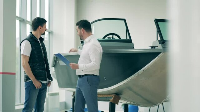 Two men are discussing purchase of a speedboat