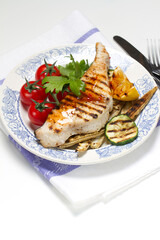 Grilled swordfish steak, young corn, zucchini, lemon, cherry tomatoes, chili sauce and celery leaf