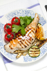 Grilled swordfish steak, young corn, zucchini, lemon, cherry tomatoes, chili sauce and celery leaf
