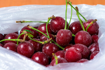 frozen cherries are covered with ice crystals and frost for winter home preparation in the freezer.