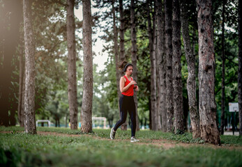 Young sporty woman jogging through the forest