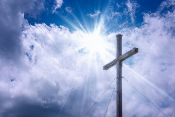 cross with sunbeamin in the sky