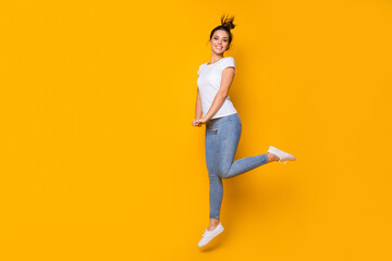 Full length body size view of her she nice-looking attractive lovely pretty slim fit thin cheerful cheery girl jumping having fun isolated over bright vivid shine vibrant yellow color background