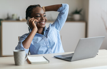 Break At Work. Happy Black Businesswoman Talking On Cellphone, Relaxing At Workplace