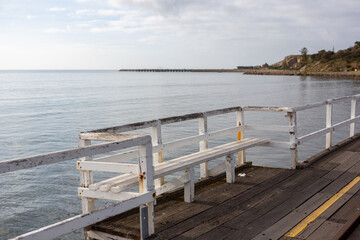 Fototapeta premium A bench seat on the Granite Island Causeway looking towards to granite island located in Victor Harbor South Australia on August 3 2020