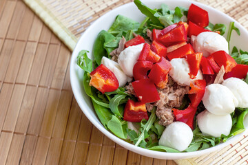 Top view of fresh summer vegetables and green herbs, red pepper, arugula, canned tuna and...