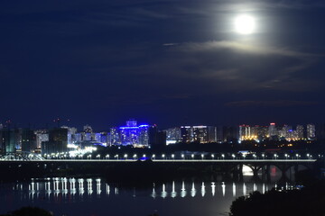Fototapeta na wymiar Night cityscape with moon. Residential district of Kyiv, Ukraine.