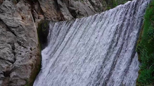 Static shot of waterfall top part with rocks and water flowing