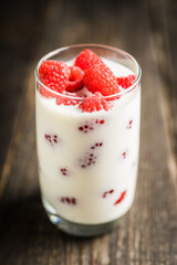 Milk with raspberry in the glass. Selective focus. Shallow depth of field.