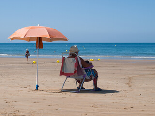 lady under an umbrella on the beach of the atlantic ocean on vacation