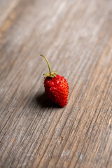 Freshly harvested wild strawberry on the rustic wooden background. Selective focus. Shallow depth of field.