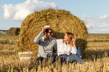 Portrait of lovers on hay background. Happy smiling couple in love during a picnic in field.