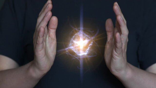 Woman praying, creates and holds a clot of vital energy in her palms. Glowing lights in woman hands. Concept of sharing, giving, offering, taking care, protection.