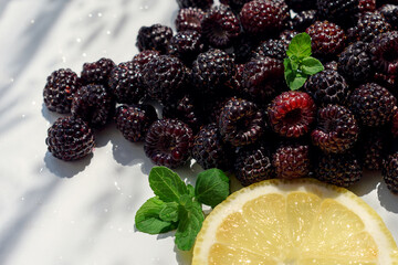 ripe juicy blackberries with slice of lemon and green leaves of fresh mint. natural products for a healthy diet