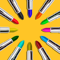 Obraz premium Set of colored lipstick on a bright yellow background. Minimal style. Top view with a copy of the space.