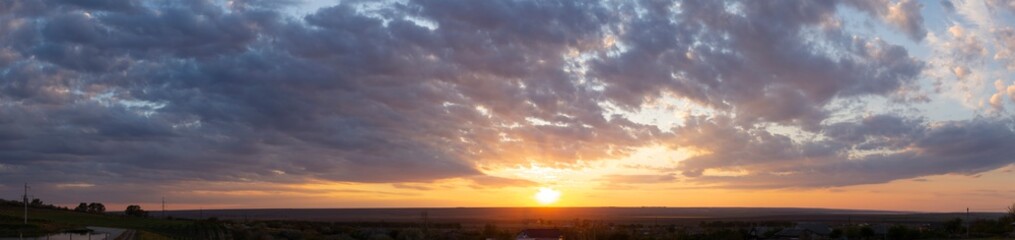 Landscape at sunset. Tragic gloomy sky. The village in the Budjak steppe. The terrain in southern Europe. Panorama.