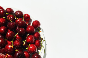 Ripe sweet cherries on plate isolated on white background with copy space