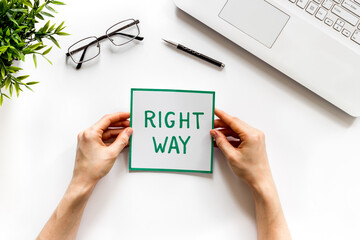 Fototapeta premium Business desicion. Right way icon in hand on white desk top view