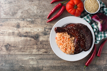 Traditional mole Poblano with rice in plate on wooden table.Top view. Copy space	