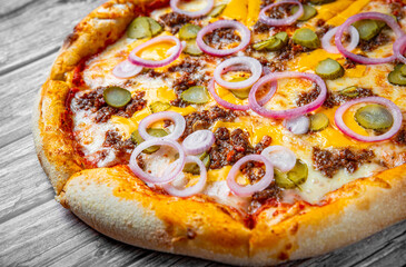 Pizza with Mozzarella cheese, Bolognese sauce, minced meat and vegetables. Italian pizza on wooden background.