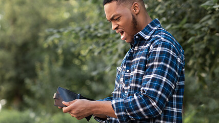 Speechless black guy looking at his empty purse