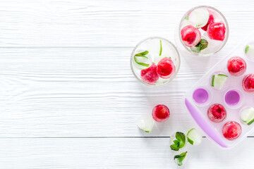 Raspberry and lime in ice cubes on white table top view copy space