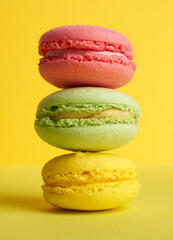 stack of baked macarons on a yellow background, delicious dessert made from almond flour