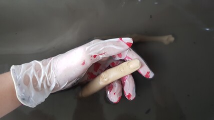 Murder investigation hand with a finger and bone in a dirty water puddle