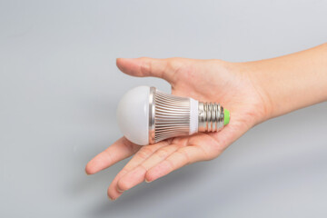 Hand held glass bulb on gray background