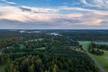 Beautiful sunset over the small town. Fields and trees around. Aerial photography.