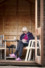 Senior lady in garden shed relaxing in retirement