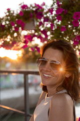 Beautiful woman wearing sunglasses at sunset by the river. Beauty and Fashion luxury style