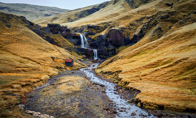 Amazing Icelandic landscape with Powerful waterfall in basalt canyon with green grass and tipical lava moss. view of wild area. Impressively beautiful locations of Iceland, the most beautyful in world